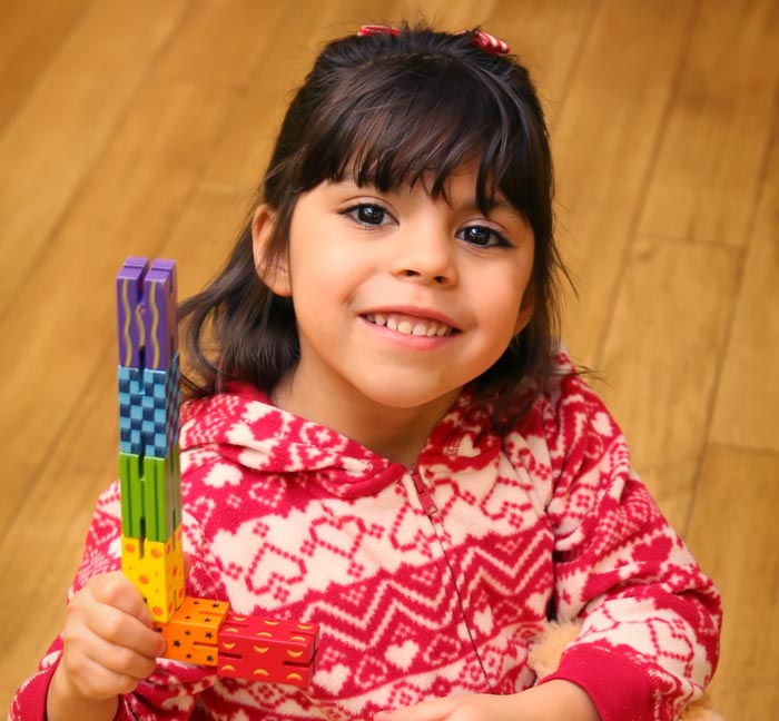 Girl playing with a toy and smiling