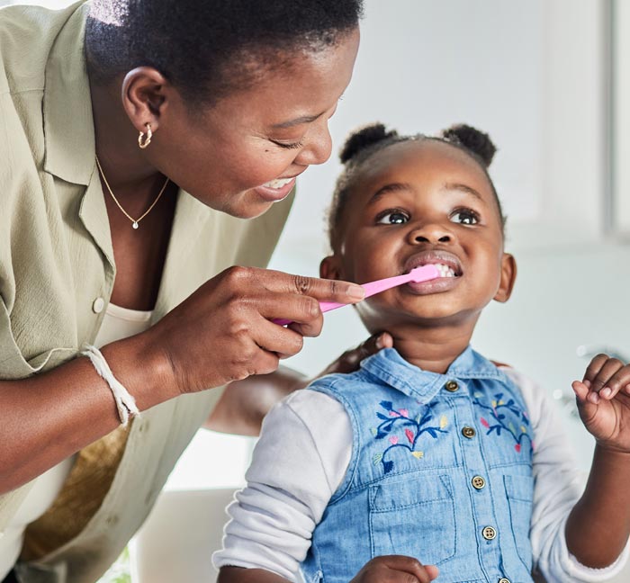 Mother brushing child's teeth